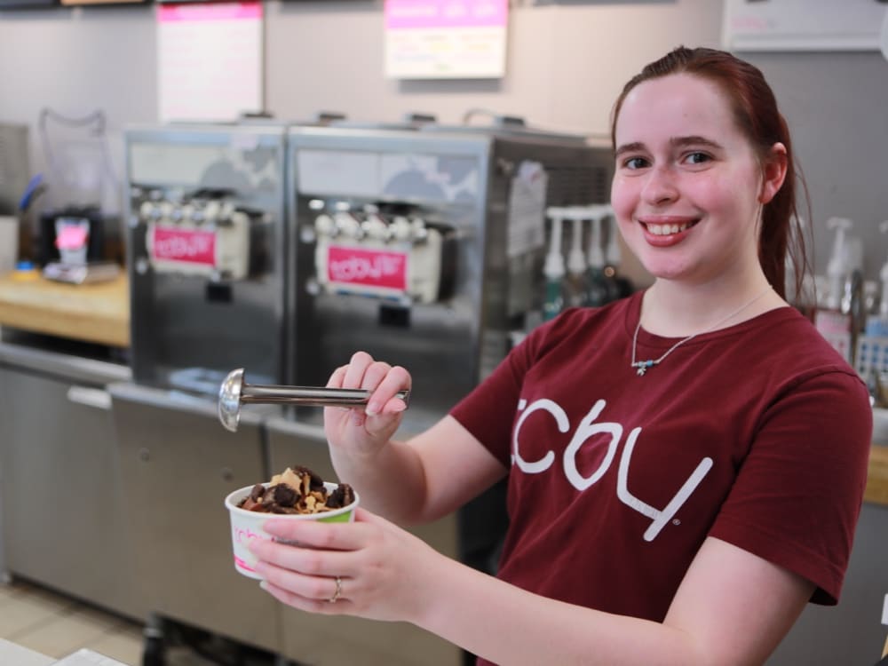 TCBY Staff filling frozen yogurt bowl